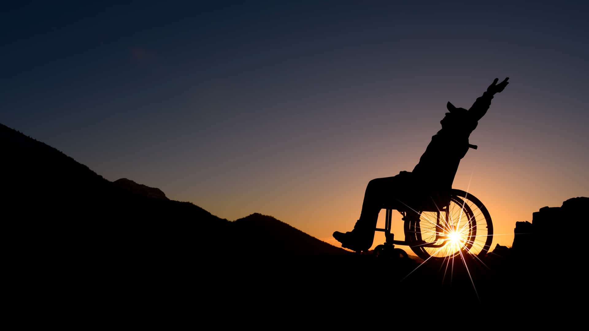 silhouette of man in wheelchair against sunset - disability attorney